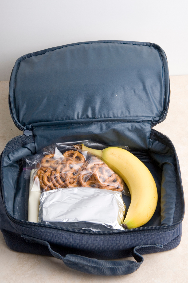 Bananas and pretzels inside a navy blue lunch bag