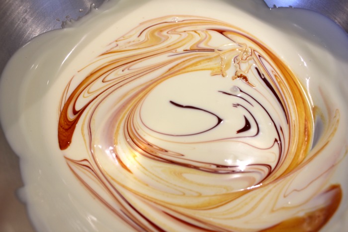 Melted chocolate in a melted bowl with yellow food coloring ready to be mixed in