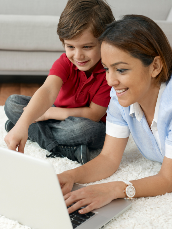 A mother and son duo spending time together on their laptop