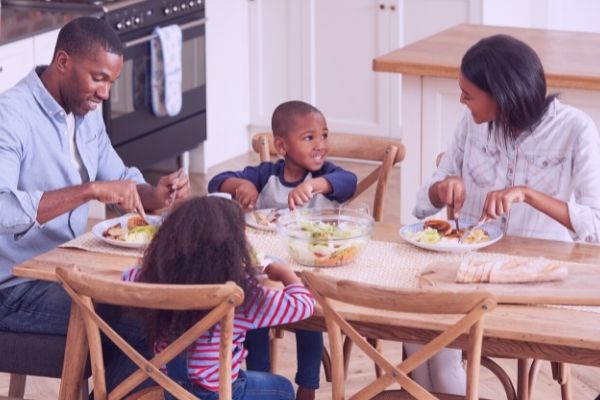 Young family gathers around the table to share a family meal